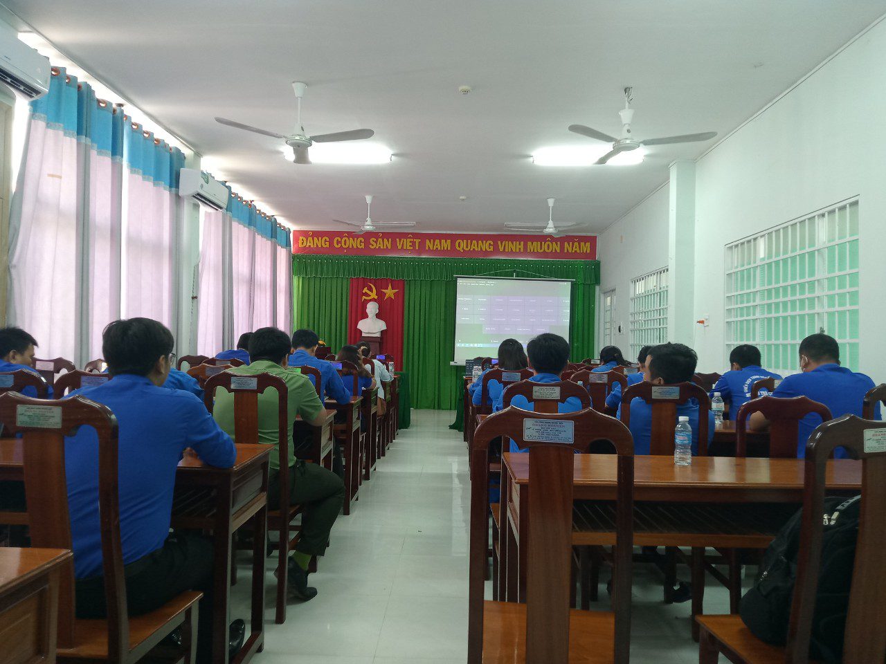 A group of people in a classroom Description automatically generated