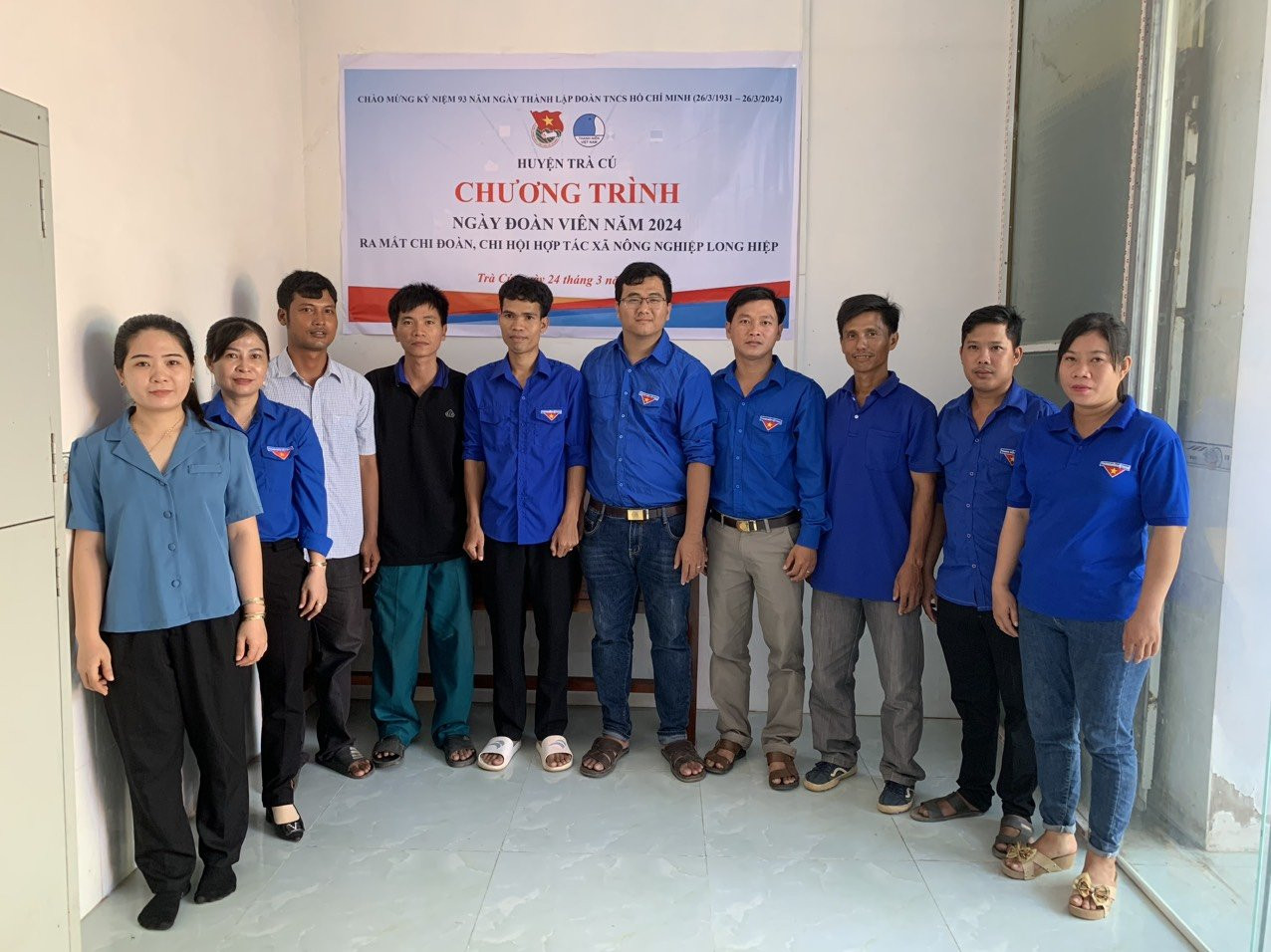 A group of people standing in a room

Description automatically generated