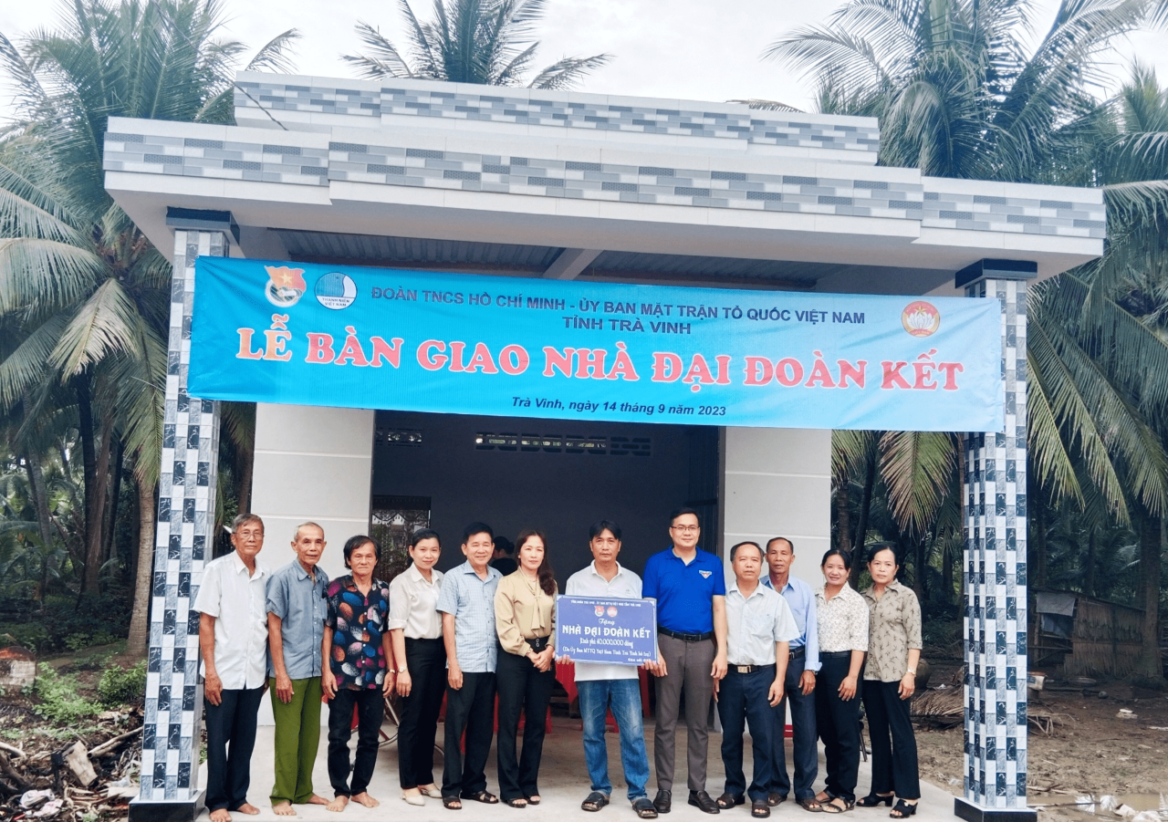 A group of people standing in front of a banner
Description automatically generated