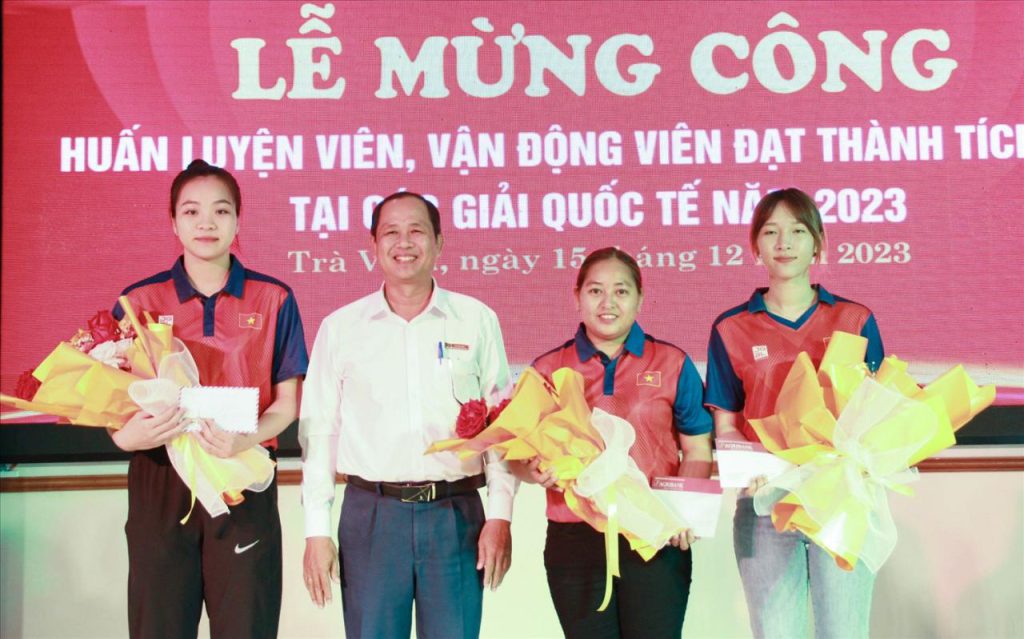 VĐV Thạch thị Ánh Lan ( thứ 2 bên phải qua) với 02 đồng đội Kim Thị Thu Thảo và Trịnh Thị Kim cùng đạt Huy chương Vàng nội dung bộ ba, được đại diện Ngân hàng Agribank Chi nhánh Trà Vinh trao thưởng động viên