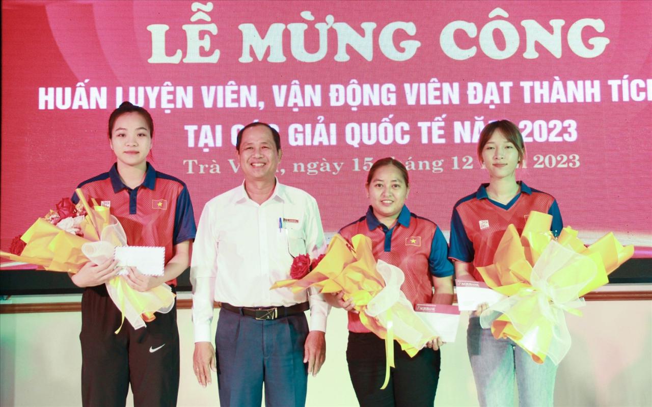 VĐV Thạch thị Ánh Lan ( thứ 2 bên phải qua) với 02 đồng đội Kim Thị Thu Thảo và Trịnh Thị Kim cùng đạt Huy chương Vàng nội dung bộ ba, được đại diện Ngân hàng Agribank Chi nhánh Trà Vinh trao thưởng động viên