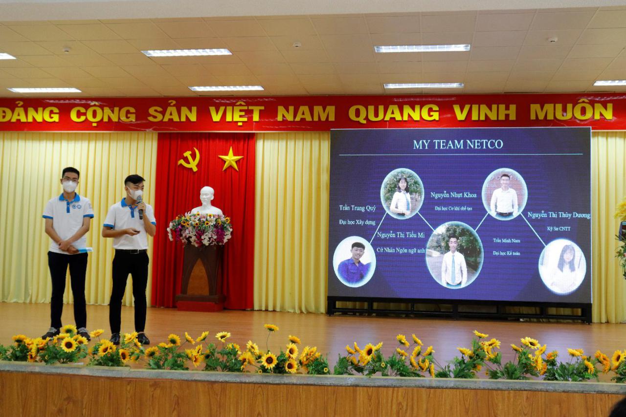 A group of people standing in front of a sign Description automatically generated with low confidence