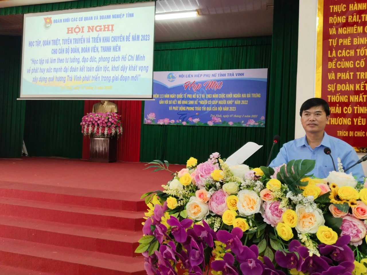 A person standing behind a podium with flowers
Description automatically generated with medium confidence