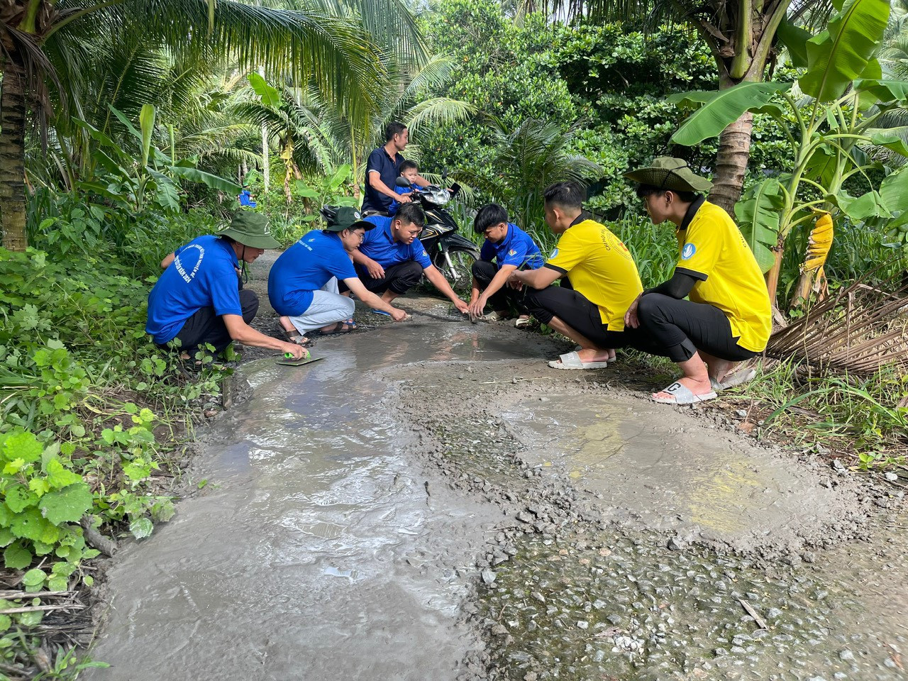 A group of people kneeling on a path in the woods Description automatically generated