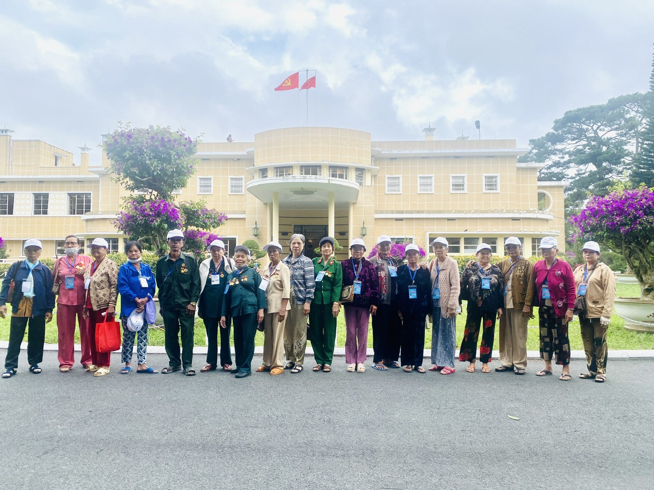 A group of people standing in front of a building Description automatically generated