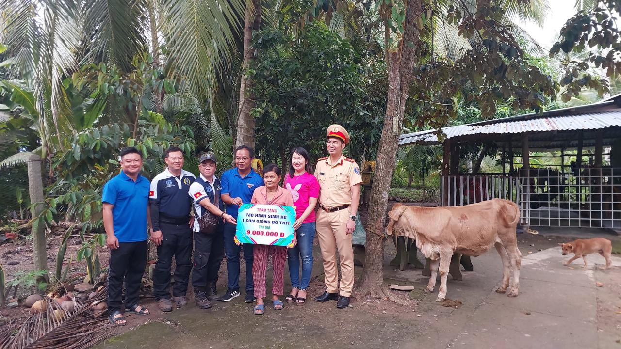 A group of people standing next to a cow Description automatically generated