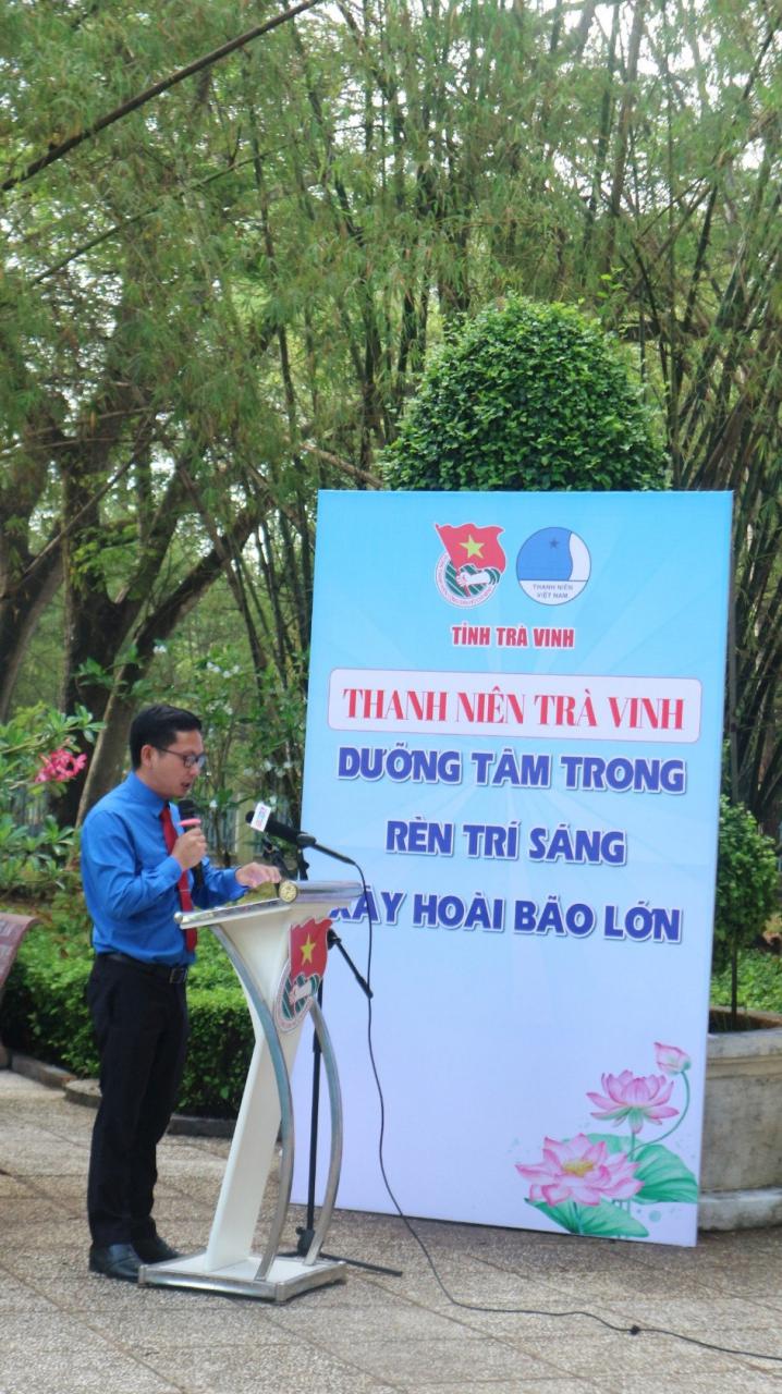 A person standing at a podium speaking into a microphone

Description automatically generated