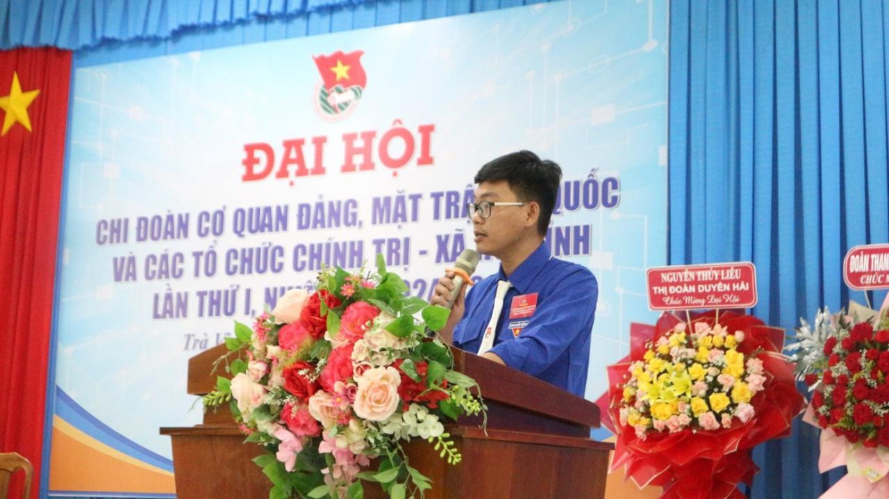 A person standing at a podium with a microphone

Description automatically generated