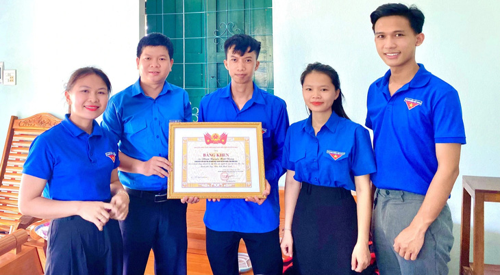 Tỉnh đoàn Bình Định trao tặng bằng khen cho anh Chung (ở giữa) vì đã có hành động nhanh trí, kịp thời cứu người bị nạn trên đầm Thị Nại - Ảnh: L.A.V