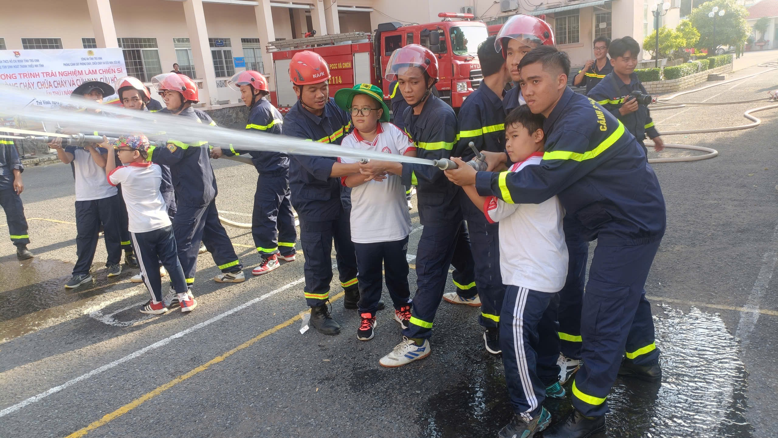 A group of people holding a hose Description automatically generated