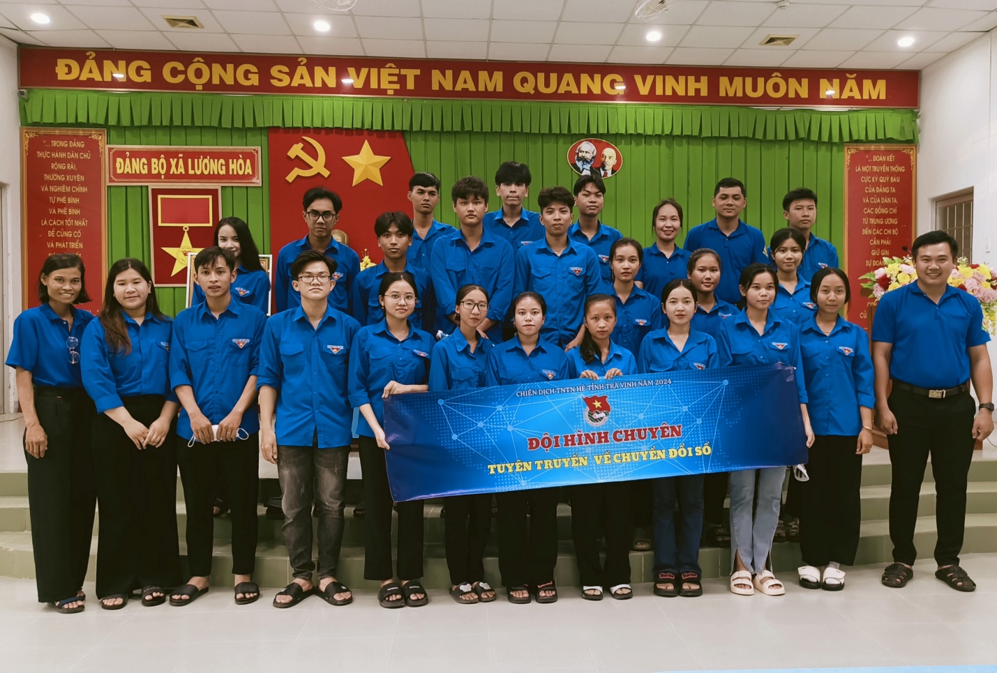 A group of people in blue shirts Description automatically generated