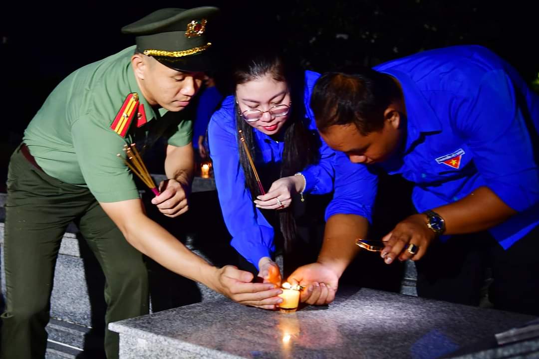 A group of people lighting a candle Description automatically generated