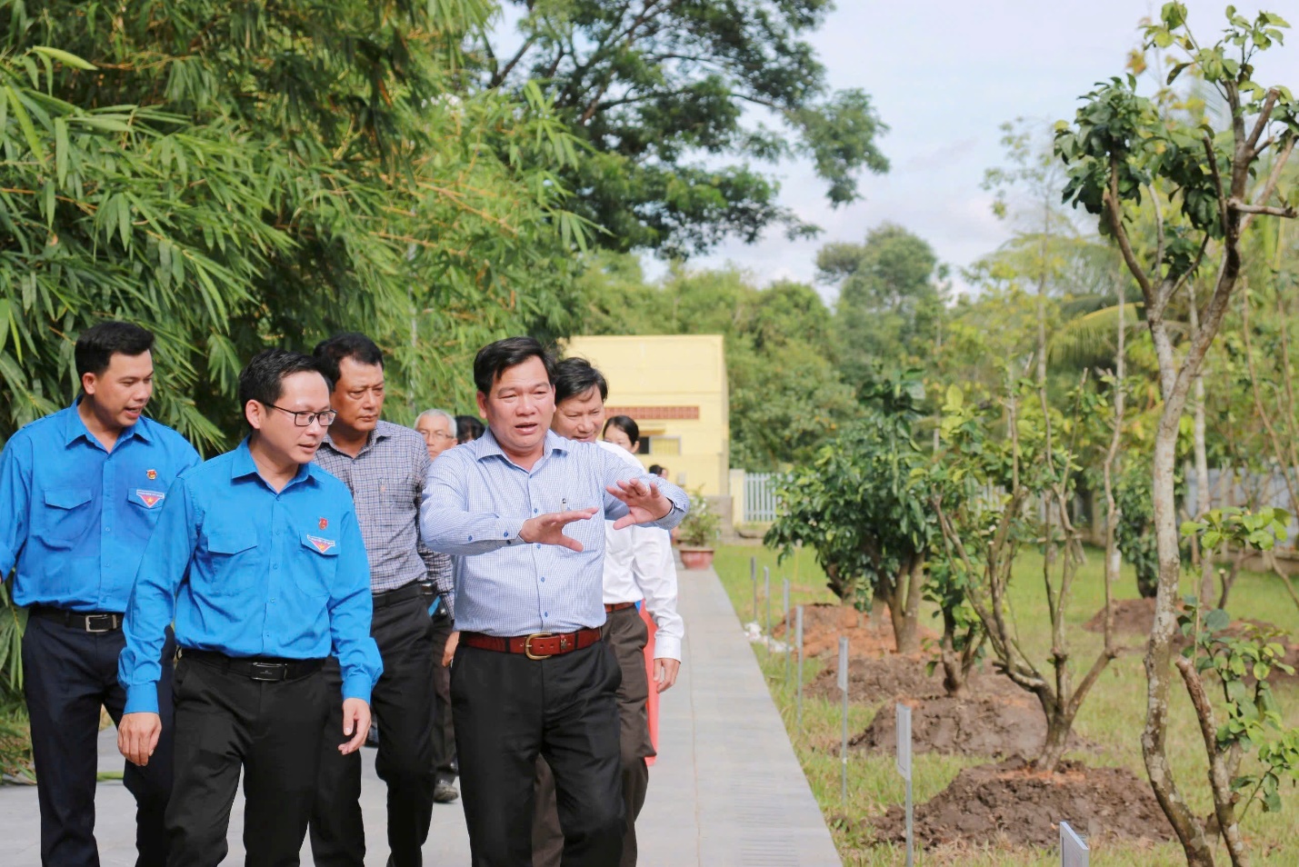 A group of people walking on a sidewalk Description automatically generated