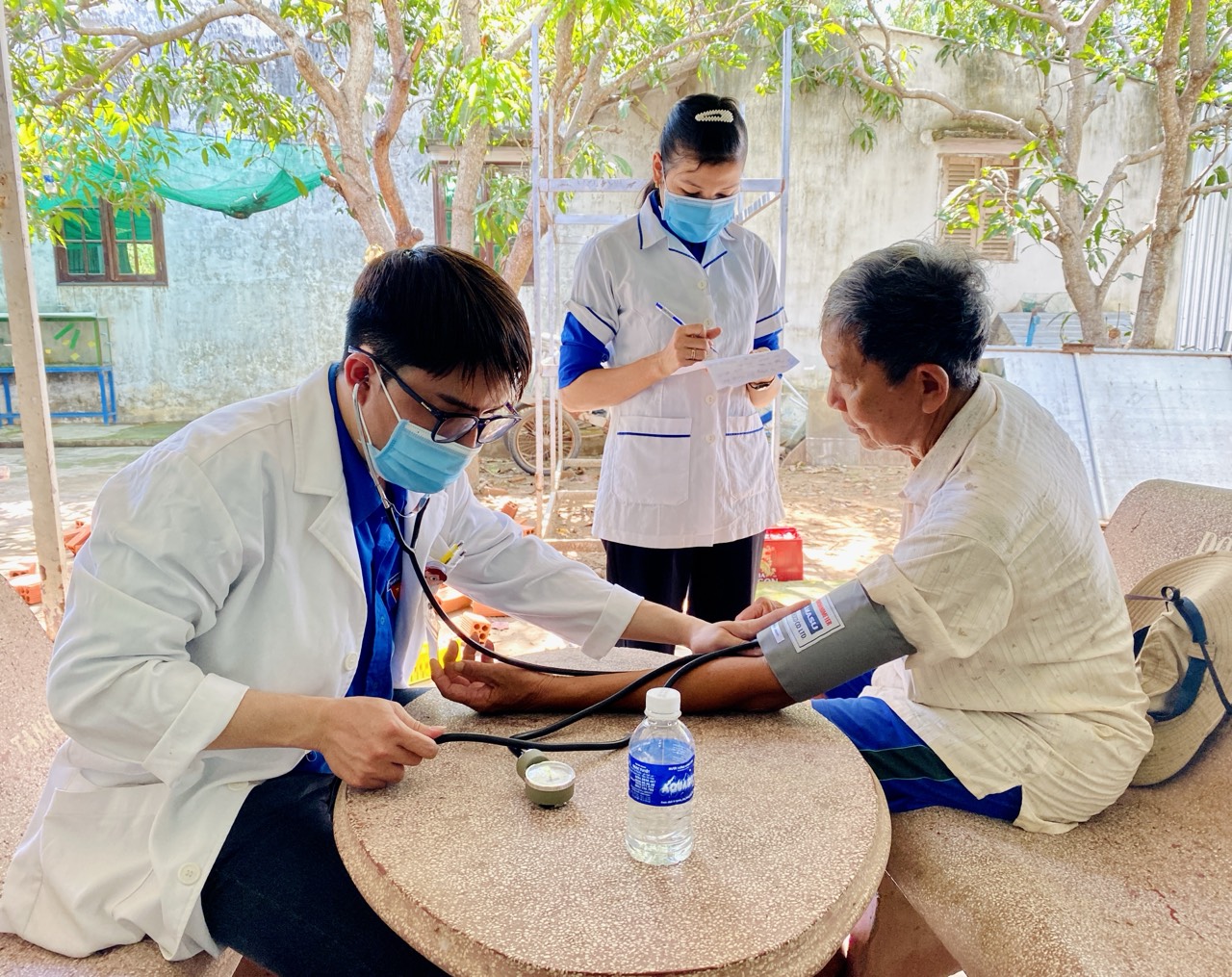 A doctor taking a blood pressure of a person Description automatically generated
