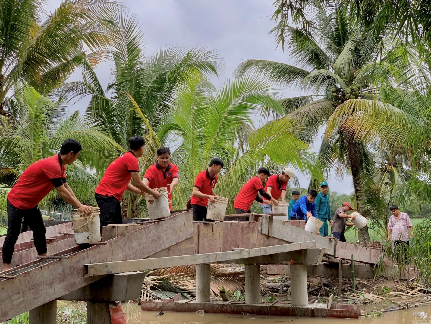 A group of people working on a bridge Description automatically generated