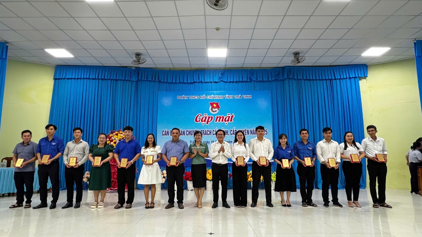 A group of people holding awards
Description automatically generated